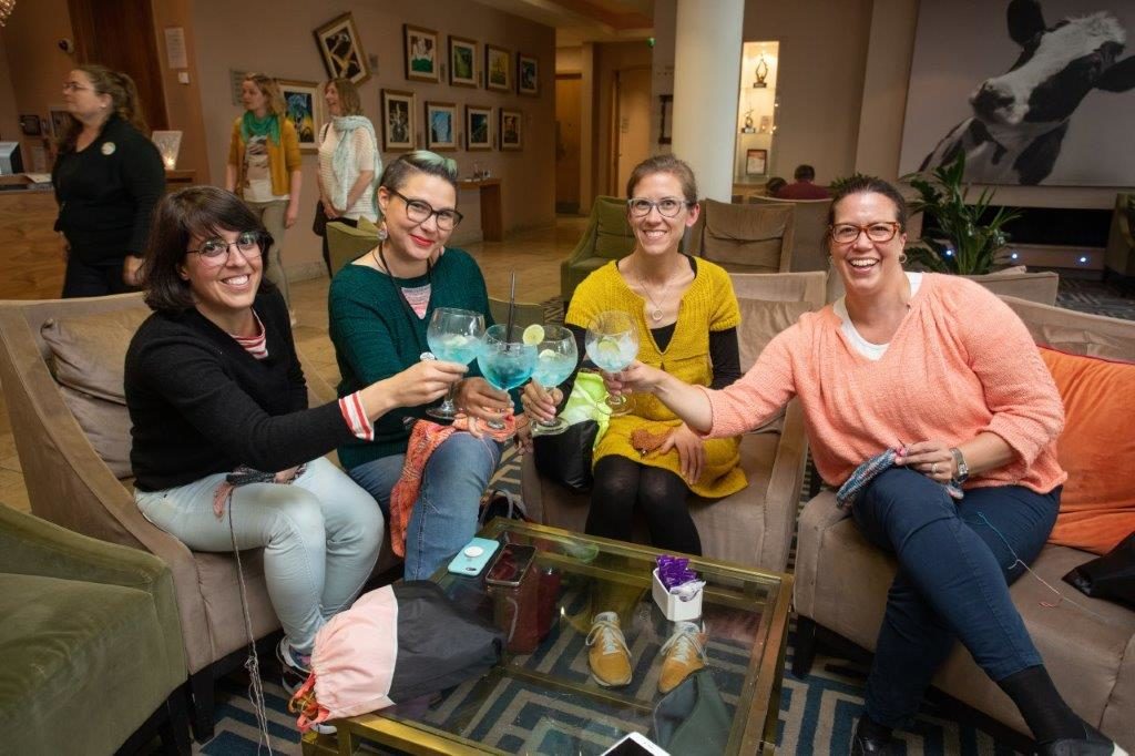 knitters enjoying a woollinn cocktail while sitting and smiling at woollinn yarn festival